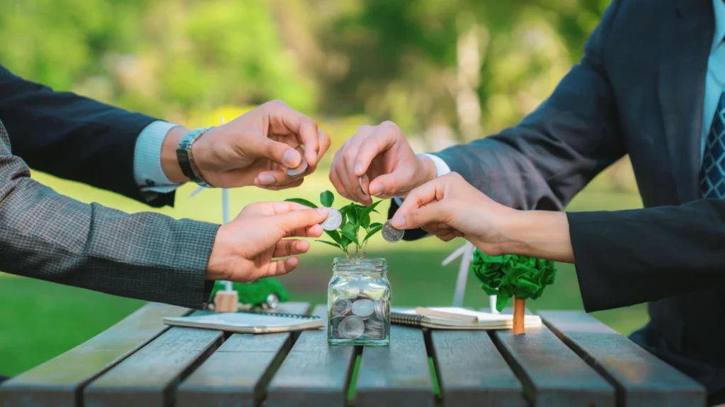 Group of people investing coins in a plant jar for social impact