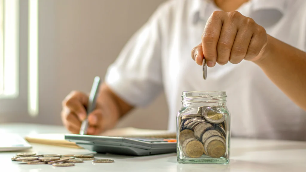 A person placing coin in jar for social returns