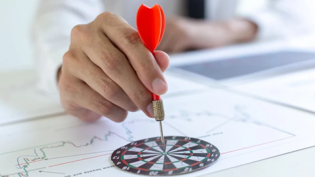 A professional person placing a red dart on a target board