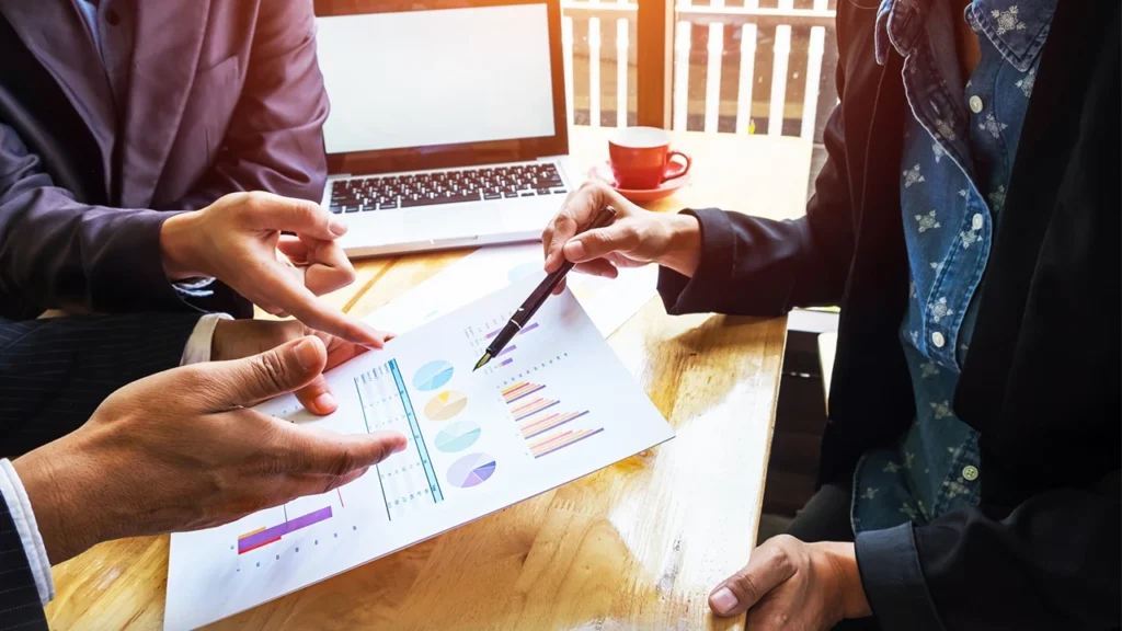 Social impact consulting firm reviewing data charts for evidence based decision making